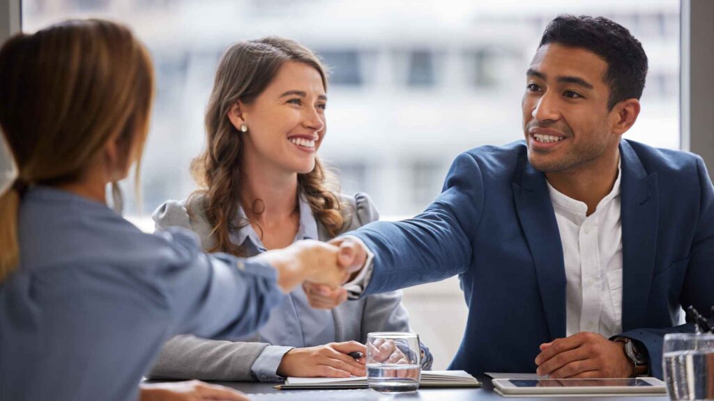 New hire shakes the hand of his boss after being hired through Legacy Staffing.