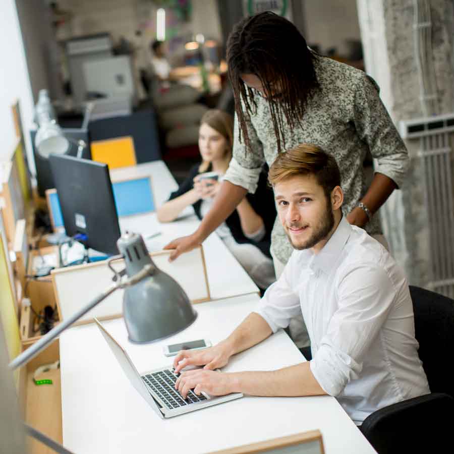 IT workers at computer after being hired by Legacy Staffing for a temp job.